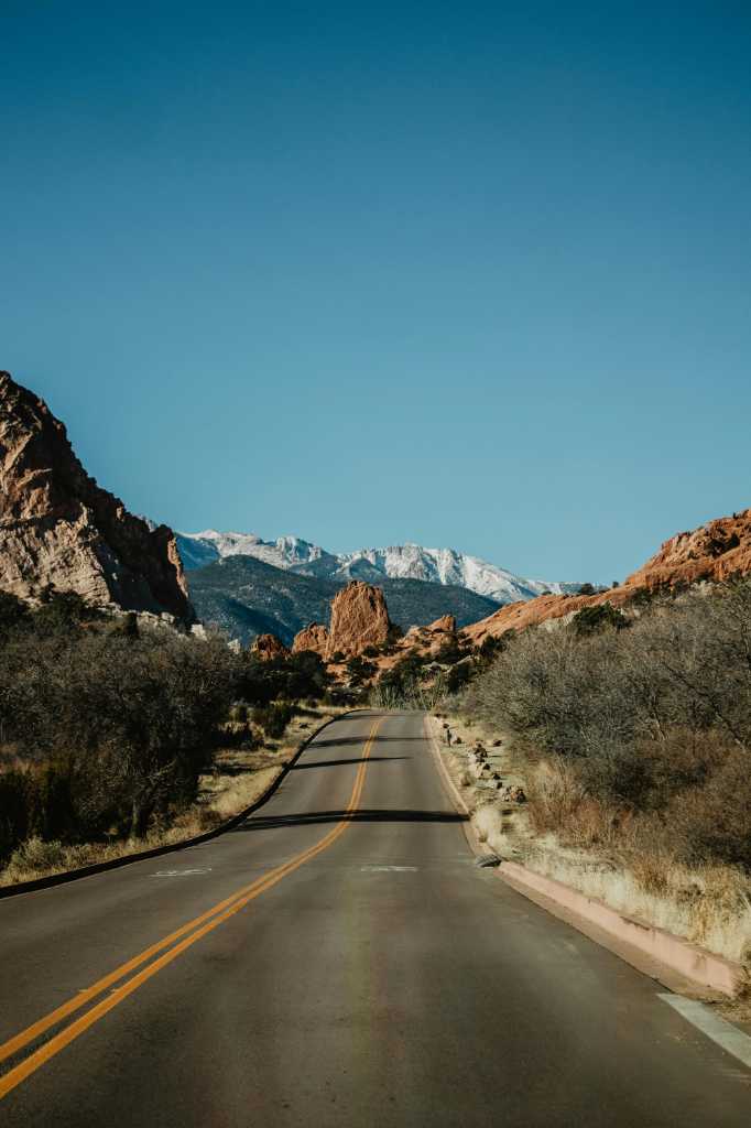 A higway in the desert next to the mountains.