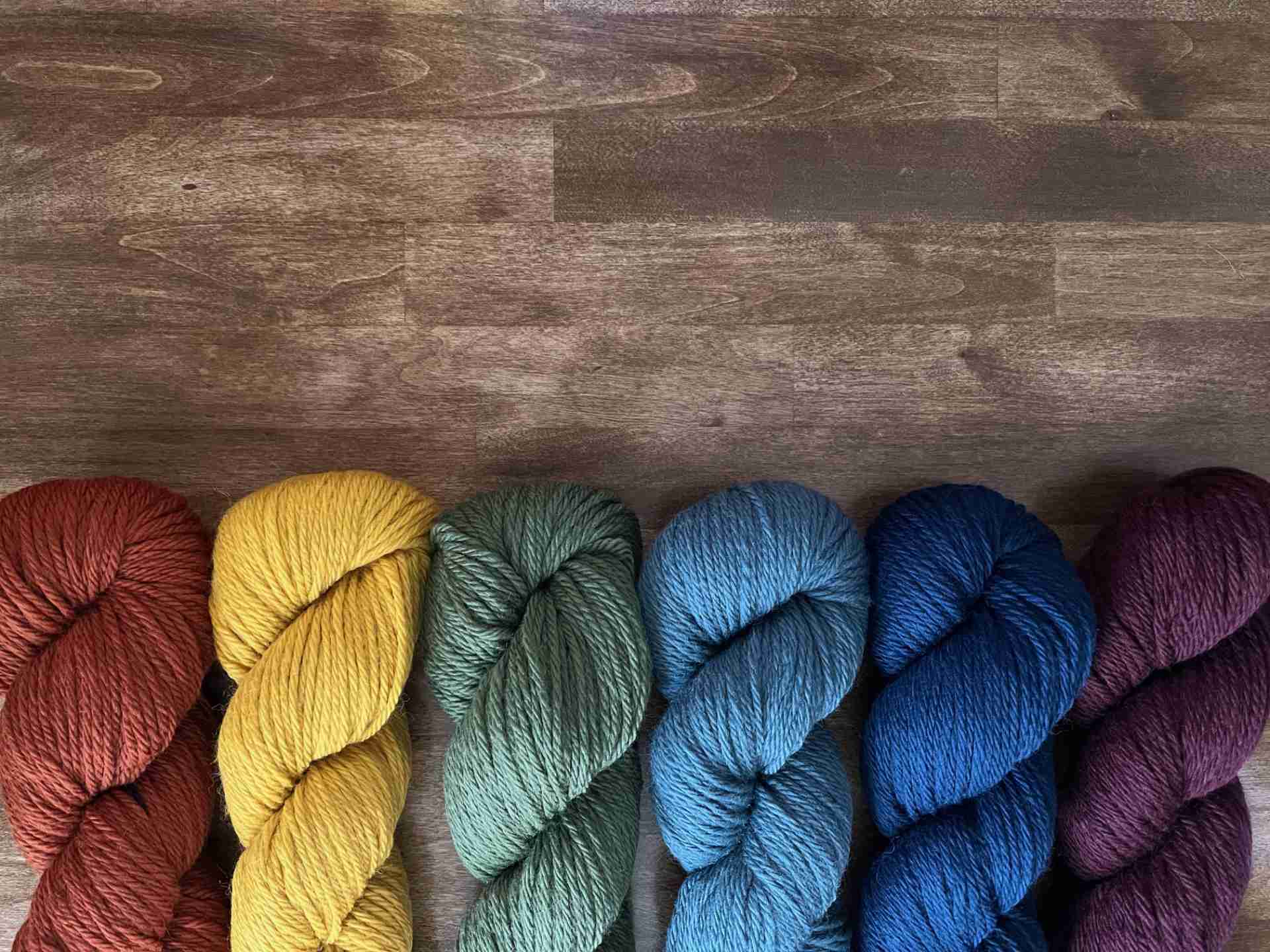Colorful skeins of yarn lined up in a row.