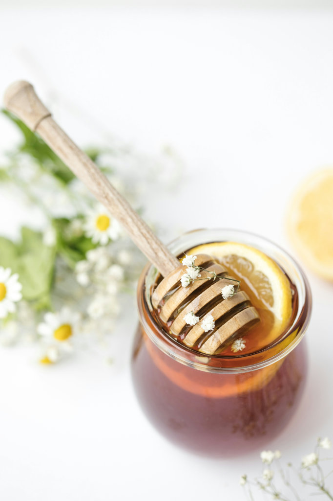 Honey dipper in a jar with a slice of lemon