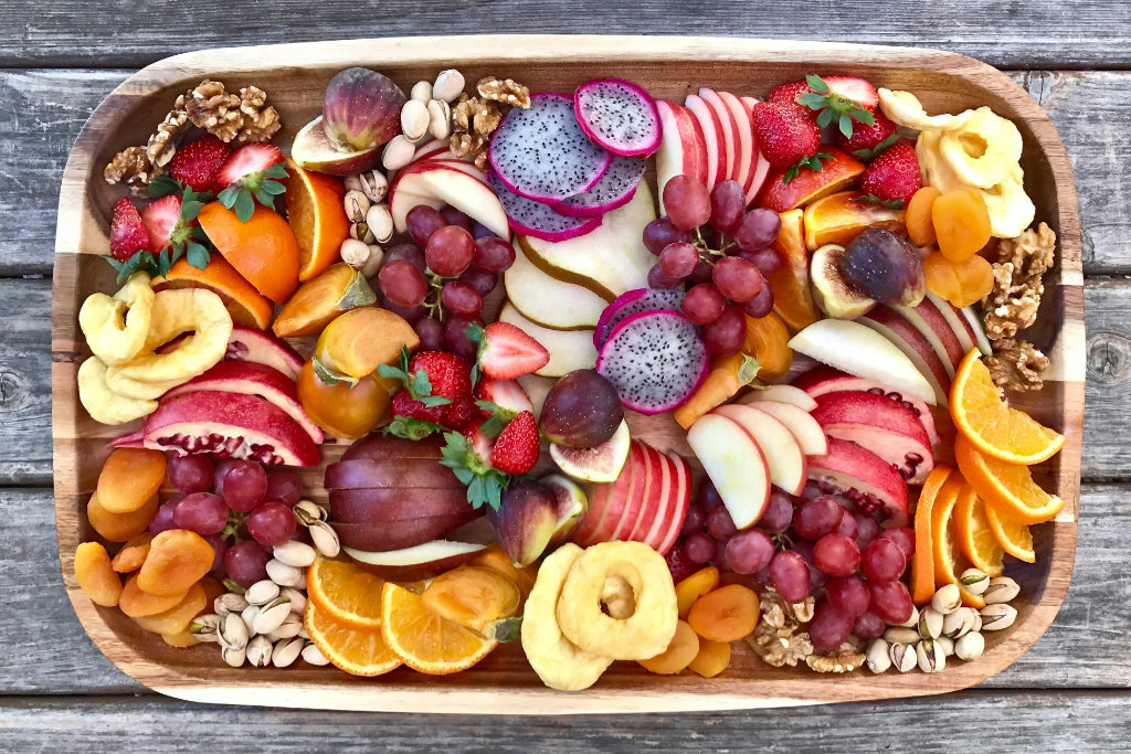 Sliced fruit arranged on a beautiful wood tray