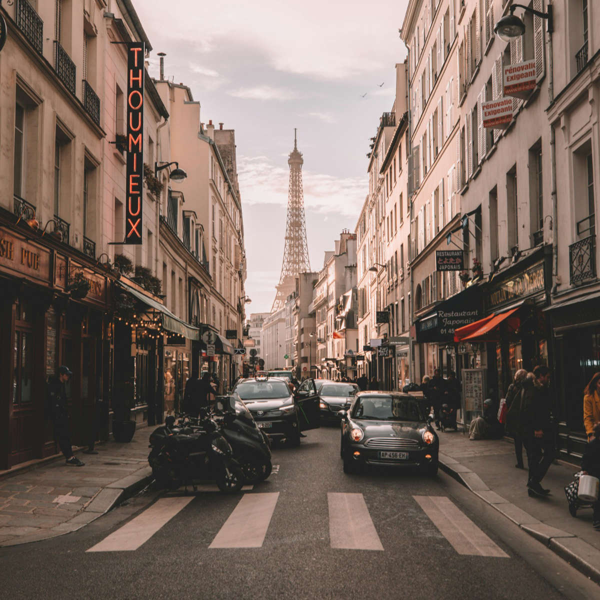 Eiffel tower in the background of a busy street in Paris.
